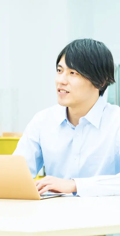 白いシャツを着た若い男性が笑顔で会話している様子。